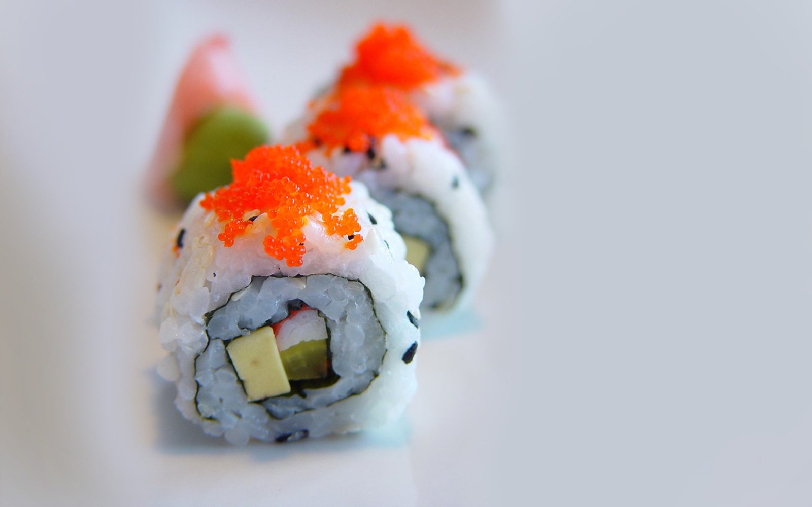 Sushi rolls topped with bright orange roe
